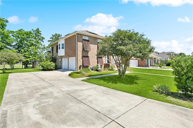 3740 Lake Lynn Dr, Gretna, LA 70056 - view of front facade with concrete driveway, an attached garage, a front lawn, roof mounted solar panels, and brick siding