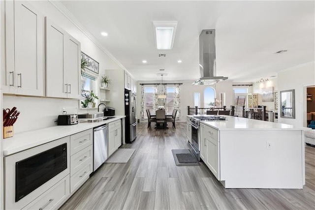 3740 Lake Lynn Dr, Gretna, LA 70056 - kitchen with appliances with stainless steel finishes, island range hood, a kitchen island, light countertops, and open floor plan
