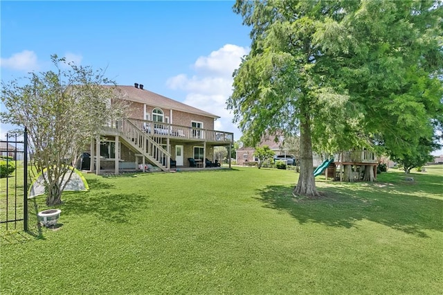 3740 Lake Lynn Dr, Gretna, LA 70056 - view of green lawn with a playground, a deck, and stairway
