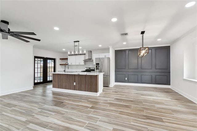 2024 Manson Ave, Metairie, LA 70001 - kitchen featuring appliances with stainless steel finishes, light countertops, recessed lighting, wall chimney range hood, and open floor plan