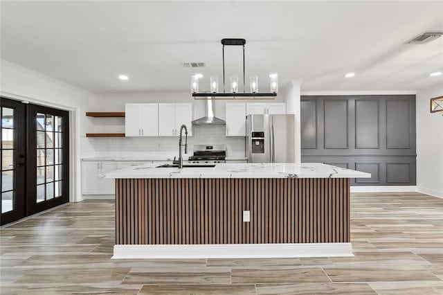 2024 Manson Ave, Metairie, LA 70001 - kitchen with appliances with stainless steel finishes, wall chimney range hood, a sink, a center island with sink, and open shelves