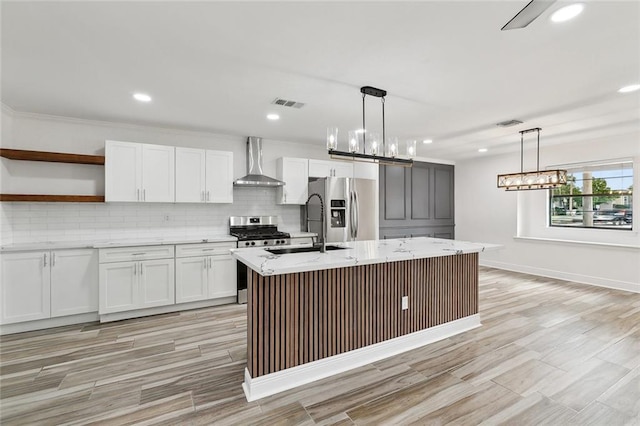 2024 Manson Ave, Metairie, LA 70001 - kitchen with wall chimney exhaust hood, stainless steel appliances, tasteful backsplash, light stone countertops, and recessed lighting