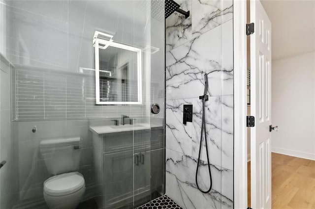 2024 Manson Ave, Metairie, LA 70001 - bathroom with a marble finish shower, wood finished floors, toilet, vanity, and tile walls