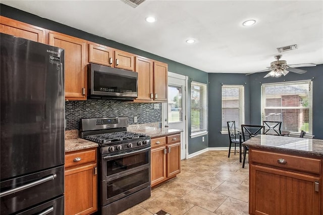255 Wilson Ln, Belle Chasse, LA 70037 - kitchen with freestanding refrigerator, range with two ovens, tasteful backsplash, ceiling fan, and recessed lighting