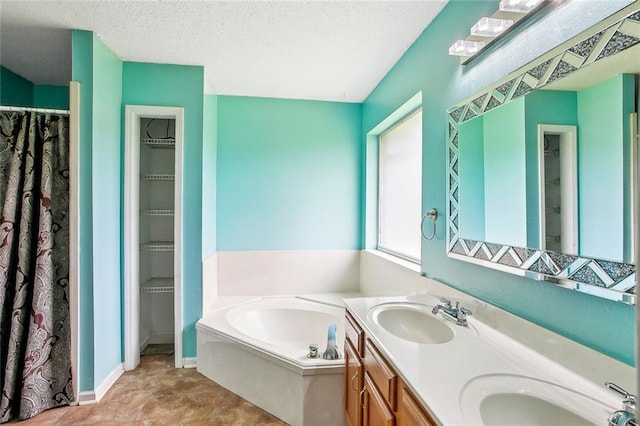 255 Wilson Ln, Belle Chasse, LA 70037 - bathroom with double vanity, a bath, baseboards, and a textured ceiling