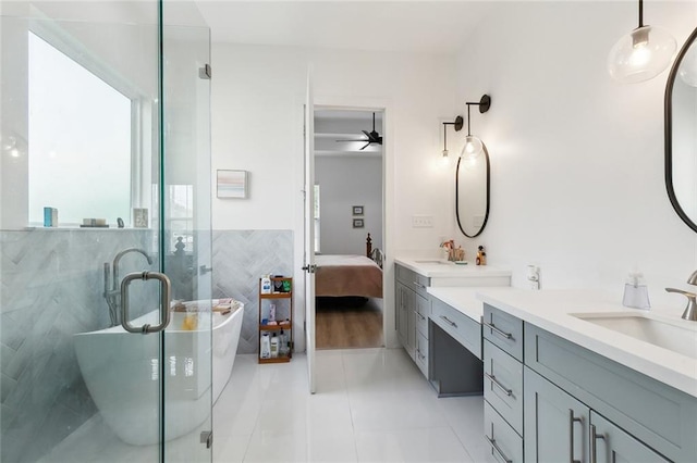 2535 Athis St, New Orleans, LA 70122 - full bathroom featuring vanity, tile walls, a freestanding bath, a shower stall, and ensuite bath