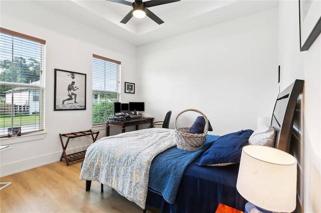 2535 Athis St, New Orleans, LA 70122 - bedroom with wood finished floors, baseboards, a tray ceiling, a ceiling fan, and a desk