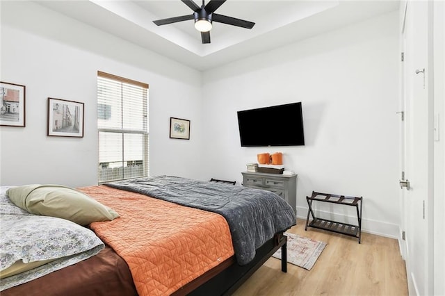 2535 Athis St, New Orleans, LA 70122 - bedroom featuring light wood-style flooring, a raised ceiling, baseboards, and a ceiling fan