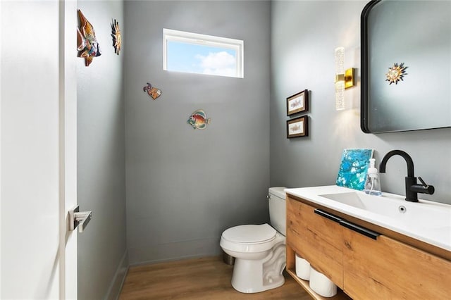 2535 Athis St, New Orleans, LA 70122 - half bath featuring toilet, vanity, wood finished floors, and baseboards