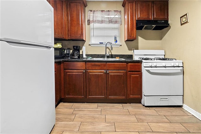 1656 Buccola Ave, Marrero, LA 70072 - kitchen with white appliances, under cabinet range hood, a sink, dark countertops, and wood finish floors