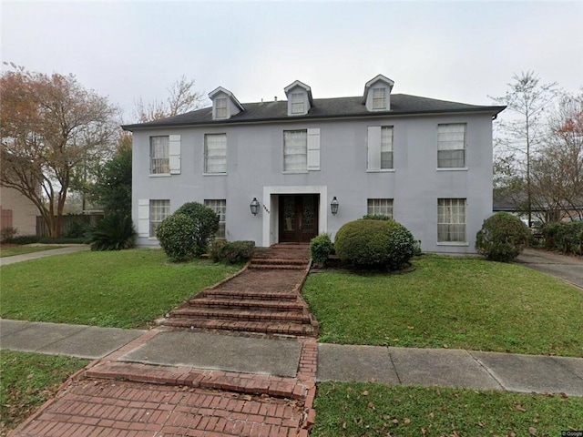 3867 N Teak Ave, New Orleans, LA 70131 - view of front of house with french doors, a front lawn, and stucco siding