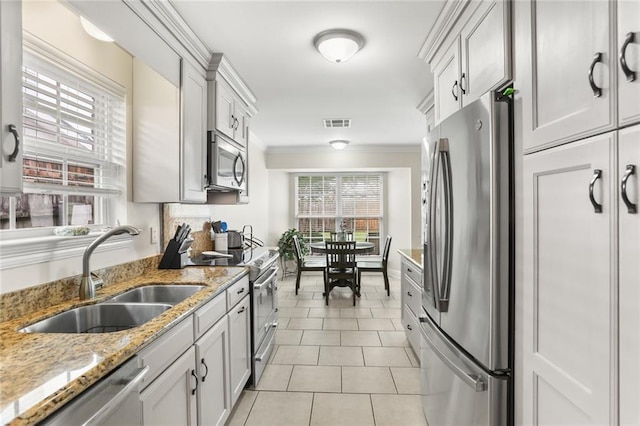 1113 Linwood Ave, Metairie, LA 70003 - kitchen featuring appliances with stainless steel finishes, a sink, ornamental molding, light tile patterned flooring, and light stone countertops