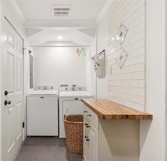 502 Audubon Trce Unit 502, Jefferson, LA 70121 - laundry area featuring washer and dryer, dark tile patterned floors, cabinet space, and electric panel
