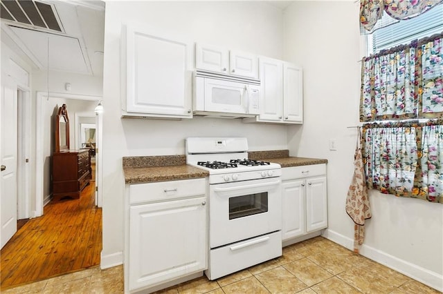 3114 Audubon St, New Orleans, LA 70125 - kitchen with white appliances, dark countertops, and white cabinetry