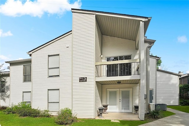 303 Parkview Blvd Unit 303, Mandeville, LA 70471 - rear view of house featuring a balcony, french doors, and a lawn