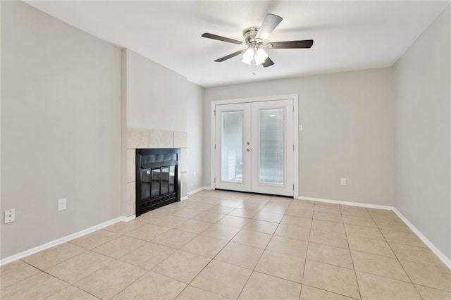303 Parkview Blvd Unit 303, Mandeville, LA 70471 - unfurnished living room featuring french doors, light tile patterned floors, a tiled fireplace, ceiling fan, and baseboards