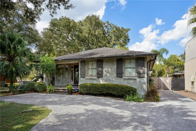 1141 Allen Toussaint Blvd, New Orleans, LA 70124 - view of front facade with driveway, a gate, and roof with shingles