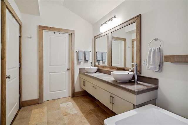 1141 Allen Toussaint Blvd, New Orleans, LA 70124 - bathroom featuring double vanity, baseboards, a soaking tub, and vaulted ceiling
