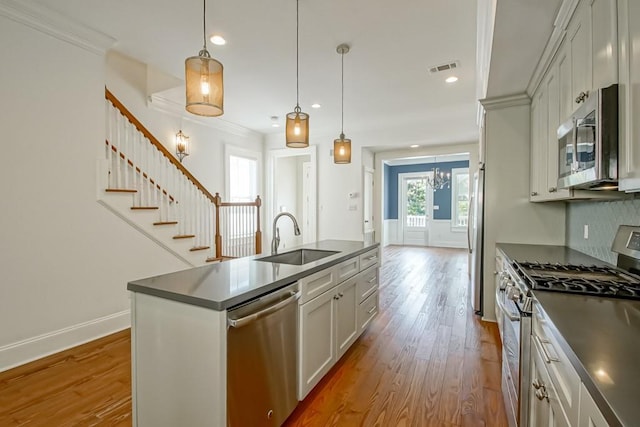 433 S Cortez St, New Orleans, LA 70119 - kitchen featuring stainless steel appliances, a sink, dark countertops, wood finished floors, and ornamental molding