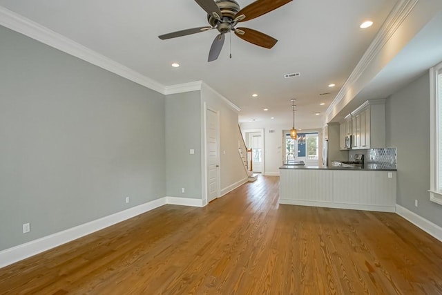 433 S Cortez St, New Orleans, LA 70119 - unfurnished living room featuring crown molding, wood finished floors, baseboards, recessed lighting, and stairway