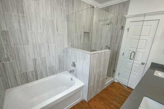 433 S Cortez St, New Orleans, LA 70119 - bathroom with a tile shower, a tub to relax in, wood finished floors, and ornamental molding