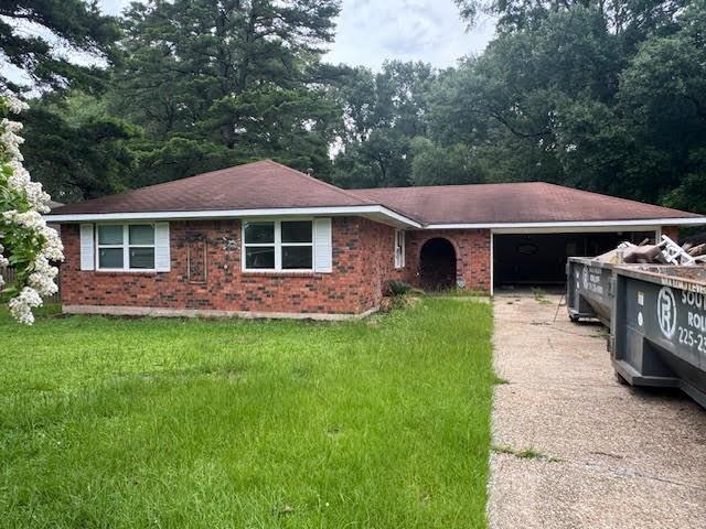 10836 Big Sur Dr, Baton Rouge, LA 70818 - ranch-style house with a garage, driveway, brick siding, and a front yard
