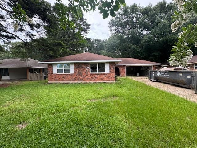 10836 Big Sur Dr, Baton Rouge, LA 70818 - view of front of house featuring a garage, a front yard, brick siding, and driveway