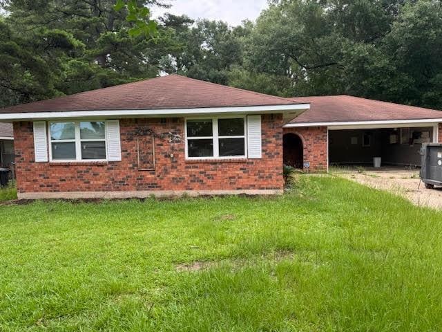 10836 Big Sur Dr, Baton Rouge, LA 70818 - view of front of home with brick siding, a front lawn, an attached garage, and central air condition unit