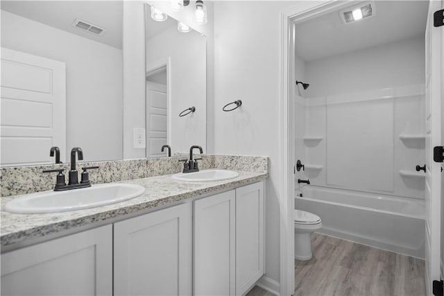 5357 Bypass Breeze Ave, Slidell, LA 70461 - bathroom featuring double vanity, toilet, wood finished floors, and bathtub / shower combination