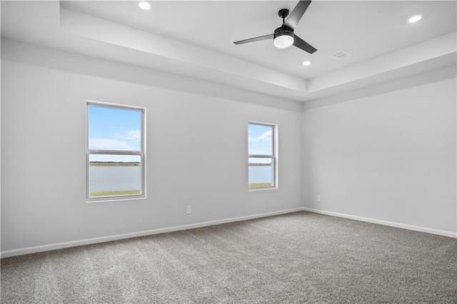 5357 Bypass Breeze Ave, Slidell, LA 70461 - spare room featuring a tray ceiling, carpet floors, recessed lighting, baseboards, and ceiling fan