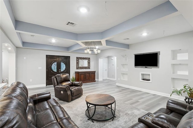 1713 Thomas St, Gretna, LA 70053 - living room with arched walkways, light wood-style flooring, built in shelves, recessed lighting, and a chandelier