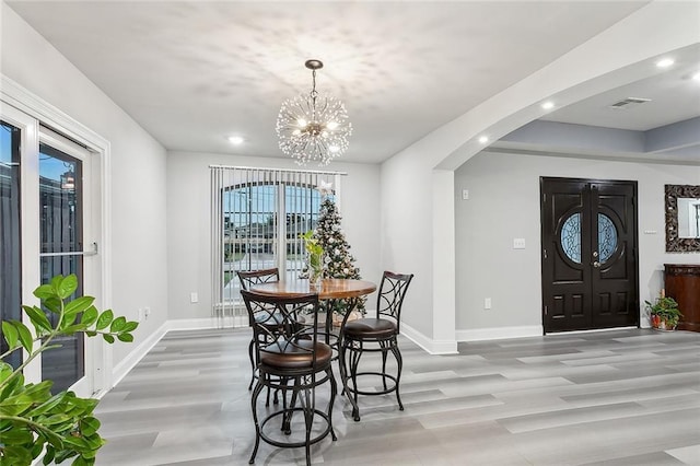 1713 Thomas St, Gretna, LA 70053 - dining space featuring arched walkways, light wood-style flooring, a chandelier, and recessed lighting