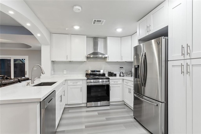 1713 Thomas St, Gretna, LA 70053 - kitchen with stainless steel appliances, wall chimney exhaust hood, recessed lighting, white cabinetry, and light countertops