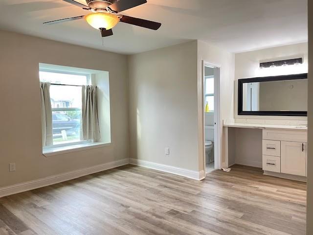 2120 Killington Dr, Harvey, LA 70058 - unfurnished bedroom with light wood-style floors, baseboards, ensuite bath, and ceiling fan