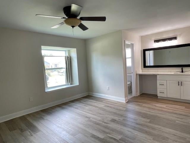 2120 Killington Dr, Harvey, LA 70058 - unfurnished bedroom featuring light wood-style floors, ensuite bathroom, and a ceiling fan