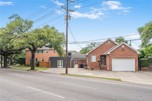 231 Audubon Blvd, New Orleans, LA 70125 - view of front of home with brick siding, a garage, driveway, and french doors