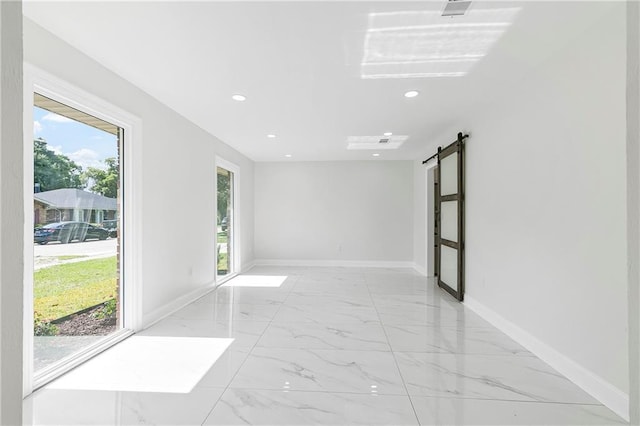 30 Normandy Dr, Kenner, LA 70065 - empty room with a barn door, light marble finish floors, recessed lighting, and baseboards