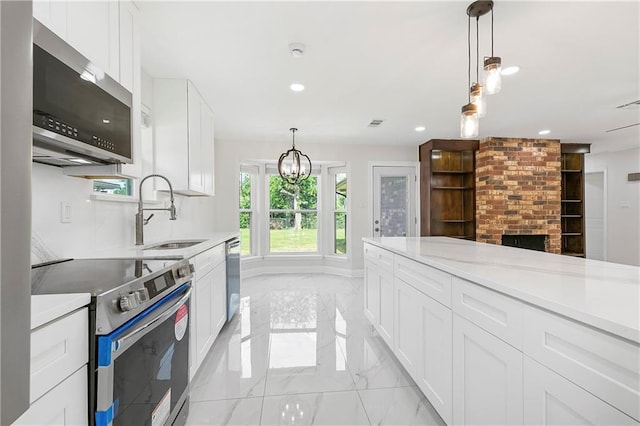 30 Normandy Dr, Kenner, LA 70065 - kitchen featuring appliances with stainless steel finishes, light marble finish flooring, a sink, recessed lighting, and light countertops