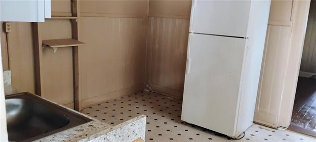 182224 Frenchmen St, New Orleans, LA 70116 - kitchen featuring freestanding refrigerator, light flooring, and a wainscoted wall