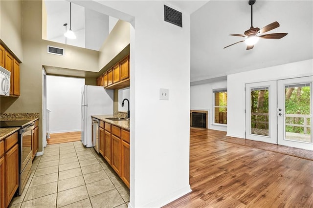 42 E Chamale Cv Unit 42, Slidell, LA 70460 - kitchen featuring appliances with stainless steel finishes, high vaulted ceiling, a sink, brown cabinetry, and light stone counters