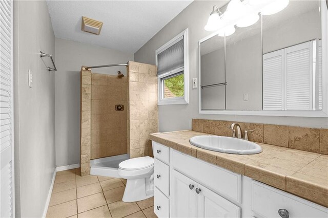 42 E Chamale Cv Unit 42, Slidell, LA 70460 - bathroom featuring toilet, vanity, tile patterned flooring, a tile shower, and a closet