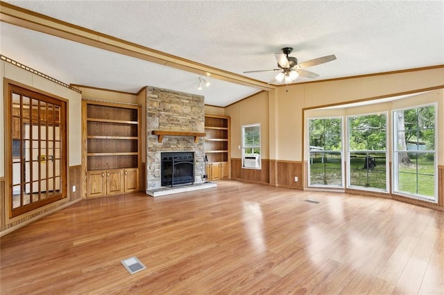 12175 Reid Rd, Amite, LA 70422 - unfurnished living room with a textured ceiling, ornamental molding, light wood-style flooring, a ceiling fan, and built in features