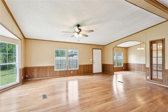 12175 Reid Rd, Amite, LA 70422 - unfurnished living room with wood finished floors, crown molding, a wainscoted wall, a textured ceiling, and a ceiling fan