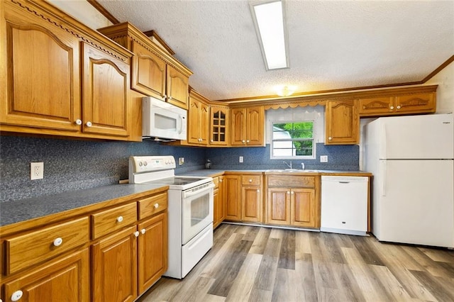 12175 Reid Rd, Amite, LA 70422 - kitchen with white appliances, brown cabinets, light wood-style floors, a sink, and a textured ceiling