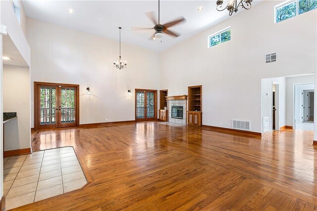 59314 Cypress Bayou Ln, Lacombe, LA 70445 - unfurnished living room featuring hardwood / wood-style floors, a chandelier, a high ceiling, french doors, and ceiling fan