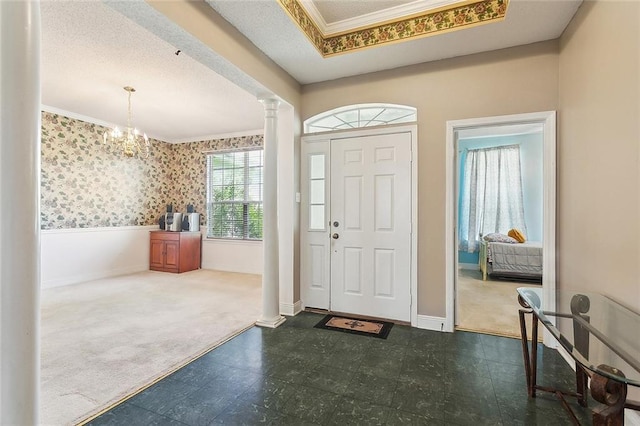 1124 Indigo Ct, Slidell, LA 70460 - entrance foyer featuring decorative columns, carpet floors, crown molding, tile patterned floors, and a chandelier