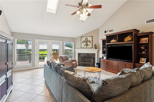 127 Windward Passage St, Slidell, LA 70458 - living room featuring vaulted ceiling, light tile patterned floors, ceiling fan, french doors, and a fireplace