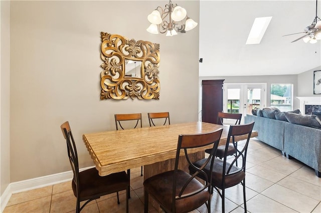 127 Windward Passage St, Slidell, LA 70458 - dining room featuring light tile patterned flooring, a ceiling fan, a chandelier, a skylight, and a fireplace