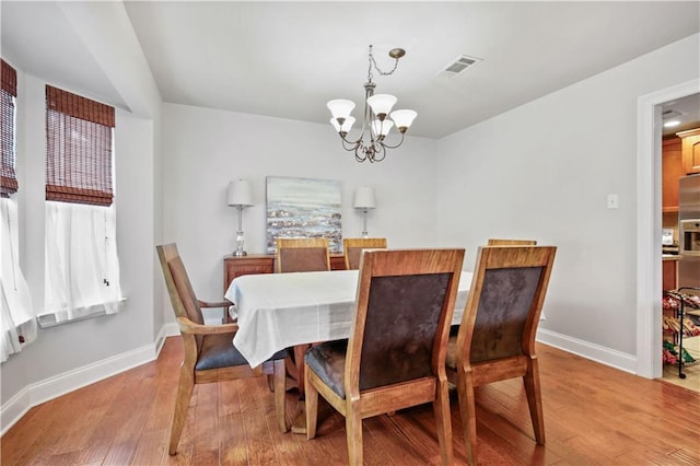 553 Manchester Dr, Slidell, LA 70461 - dining area with a chandelier, light wood-type flooring, and baseboards