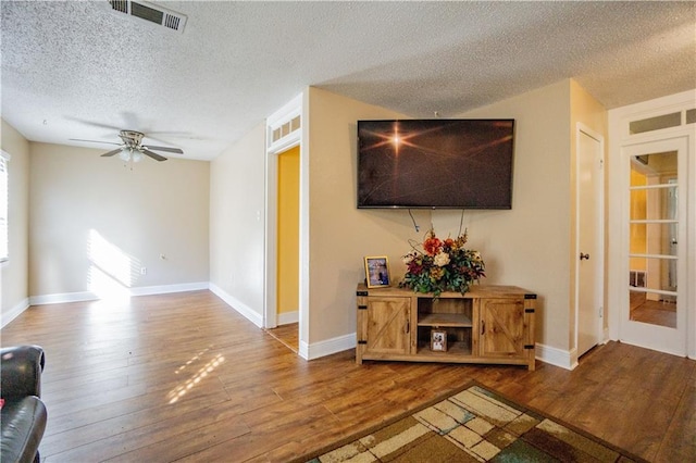 2404 Timbers Dr, Harvey, LA 70058 - living area with wood finished floors, a textured ceiling, a ceiling fan, and baseboards